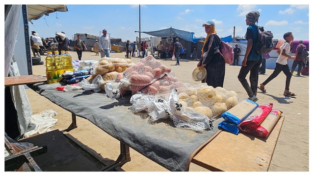 Palestinians look at foodstuffs for sale at a makeshift market in the Mawasi area of Rafah. (AFP)