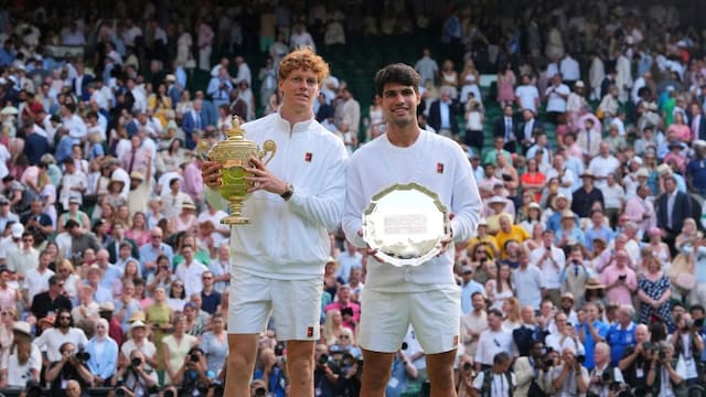 Jannik Sinner of Italy, ,left, and Carlos Alcaraz of Spain pose with the trophies after the men's singles final match at the Wimbledon Tennis Championships in London, Sunday, July 13, 2025.(AP Photo/Kirsty Wigglesworth)
