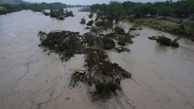A raging Guadalupe River leaves fallen trees and debris in its wake in Kerrville, Texas, on Friday. (AP)