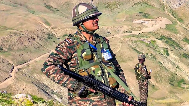 An Army personnel stands guard near the place of Kargil battle on the eve of Kargil Vijay Diwas, at Drass, in Kargil. (PTI File)