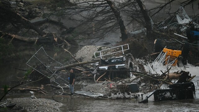 A member of the public stands next to overturned vehicles and broken trees after flooding caused by a flash flood at the Guadalupe River in Kerrville, Texas. (AFP photo)
