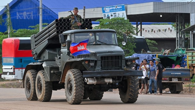 A Cambodian soldier stands on a truck carrying a Russian-made BM-21 rocket launcher travelling along a street in Oddar Meanchey province on July 25. (AFP photo)