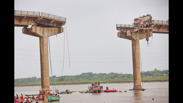 Rescuers and locals look used boats to look for survivors after several vehicles fell into the river following the collapse of a portion of a bridge in Mujpur near Vadodara. (AP)