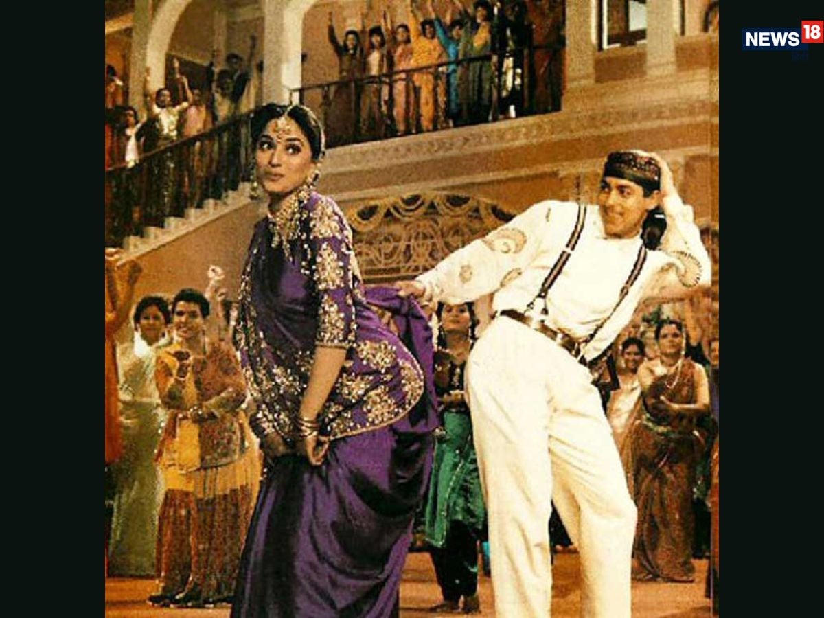 Madhuri Dixit’s purple saree in Hum Aapke Hain Koun..! during the song Didi Tera Devar Deewana turned into a wedding classic. With her braided hairstyle, nose ring and effortless elegance, the look defined bridal festivities for years to come. (News18 Hindi) Madhuri Dixit’s purple saree in Hum Aapke Hain Koun..! during the song Didi Tera Devar Deewana turned into a wedding classic. With her braided hairstyle, nose ring and effortless elegance, the look defined bridal festivities for years to come. (News18 Hindi)