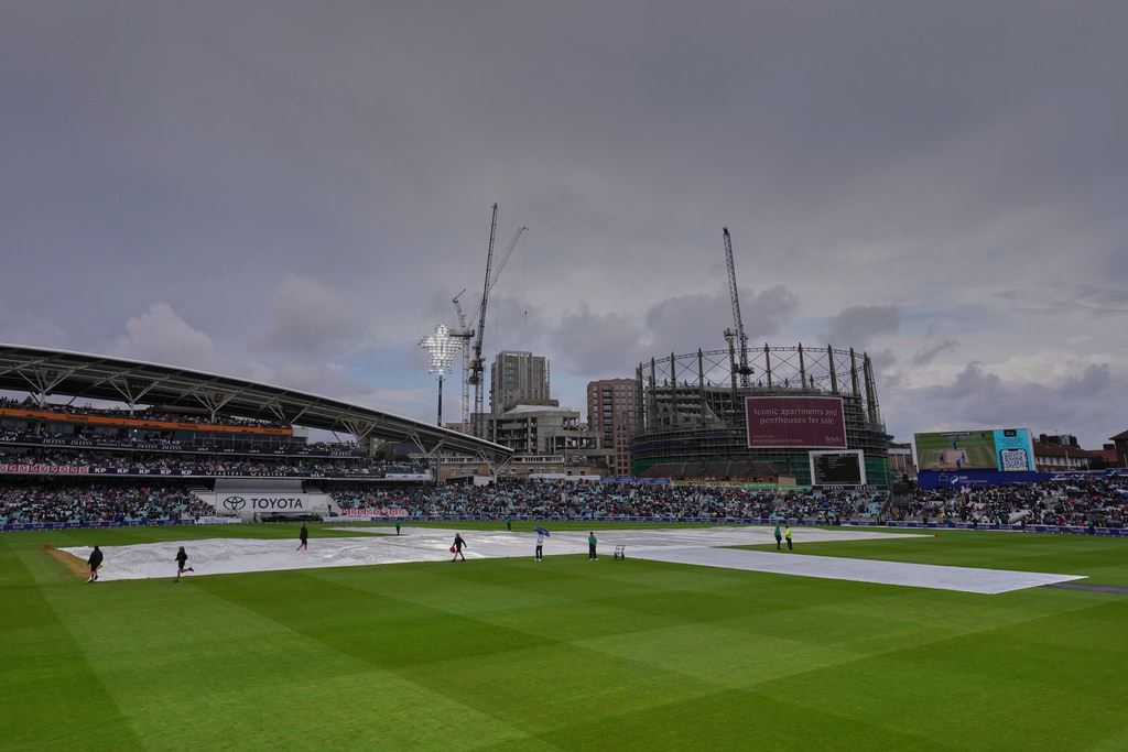Groundsmen cover the pitch to protect from rain (AP) Groundsmen cover the pitch to protect from rain (AP)
