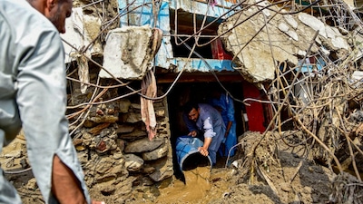 A resident removes sludge from his damaged house a day after flash floods in Pakistan's mountainous Khyber Pakhtunkhwa province. (AFP photo)