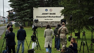 Journalists work near an entrance to Joint Base Elmendorf-Richardson in Anchorage, Alaska, on August 14, 2025, ahead of the August 15 scheduled meeting between US President Donald Trump and Russian President Vladimir Putin. (AFP)