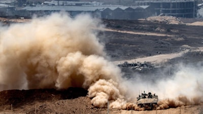 An Israeli army infantry-fighting vehicle (IFV) leaves a cloud of dust as it moves at a position along Israel's southern border with the Gaza Strip on August 5. (AFP photo)