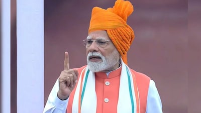  PM Narendra Modi donned a bright saffron turban, paired with a Nehru jacket over a crisp white kurta set. The simplicity of the kurta provided a clean backdrop for the more striking accessories, including a cream stole with a tricolour-inspired border, symbolising the nation’s history, unity, and pride. (File Photo)