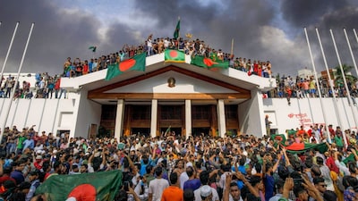 People gather around the residence of Sheikh Hasina in Dhaka, Bangladesh, on August 5, 2024. (EPA-EFE/STR VIA PTI)