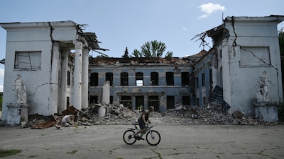 A man rides his bicycle past a destroyed building in Druzhkivka, Donetsk region, on August 15, 2025. (AFP photo)
