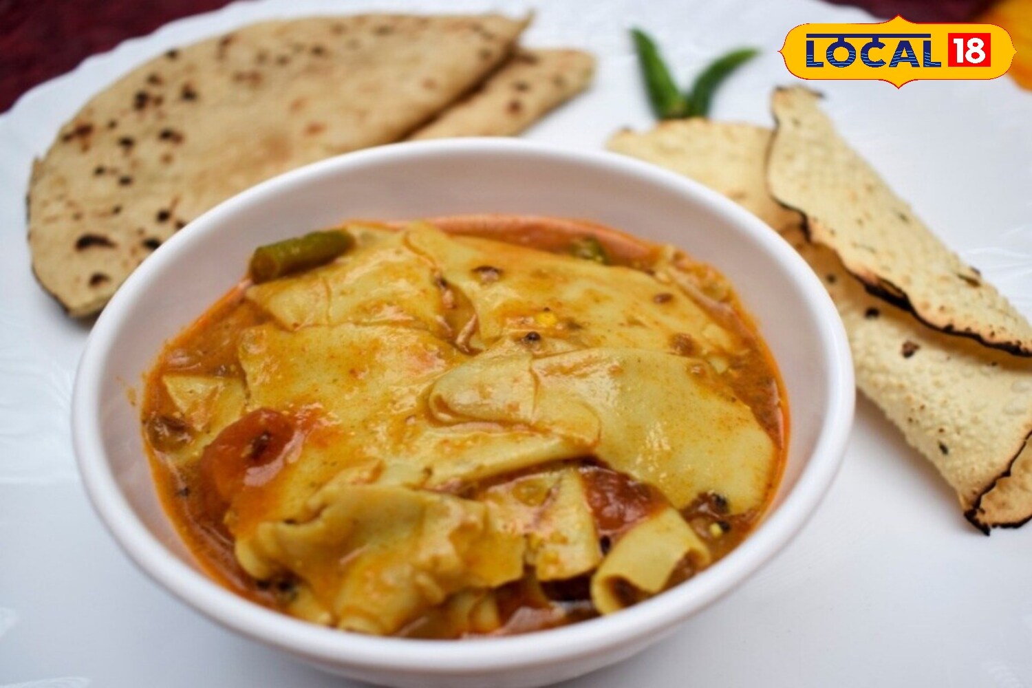 Papads are prepared separately by either roasting them on a pan or frying them lightly in oil. Once ready, they are broken into pieces and added to the gravy. It is important not to cook the papads for too long—a brief boil is enough to keep them slightly crisp. The dish is finished with garam masala and fresh coriander. (News18 Hindi) Papads are prepared separately by either roasting them on a pan or frying them lightly in oil. Once ready, they are broken into pieces and added to the gravy. It is important not to cook the papads for too long—a brief boil is enough to keep them slightly crisp. The dish is finished with garam masala and fresh coriander. (News18 Hindi)