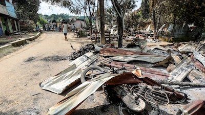 Locals look at charred remains as shops lie closed at a market area in Guimara, Khagrachari district on September 29, 2025. (AFP photo) 
