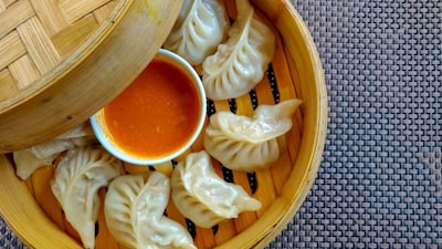 Momo: Nepal’s most beloved street food. These juicy dumplings are filled with meat or vegetables and served steamed or fried, often with spicy tomato sauce. (Image: Canva)