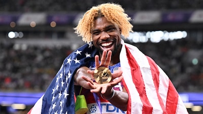 US sprinter Noah Lyles celebrates with his gold medal and a US flag after winning in the men's 200m final during the World Athletics Championships in Tokyo on September 19, 2025. (Photo by Jewel SAMAD / AFP)