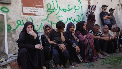 Palestinians sit outside Al-Shifa hospital where casualties of Israeli strikes on Gaza City the previous night were transported. (AFP photo)