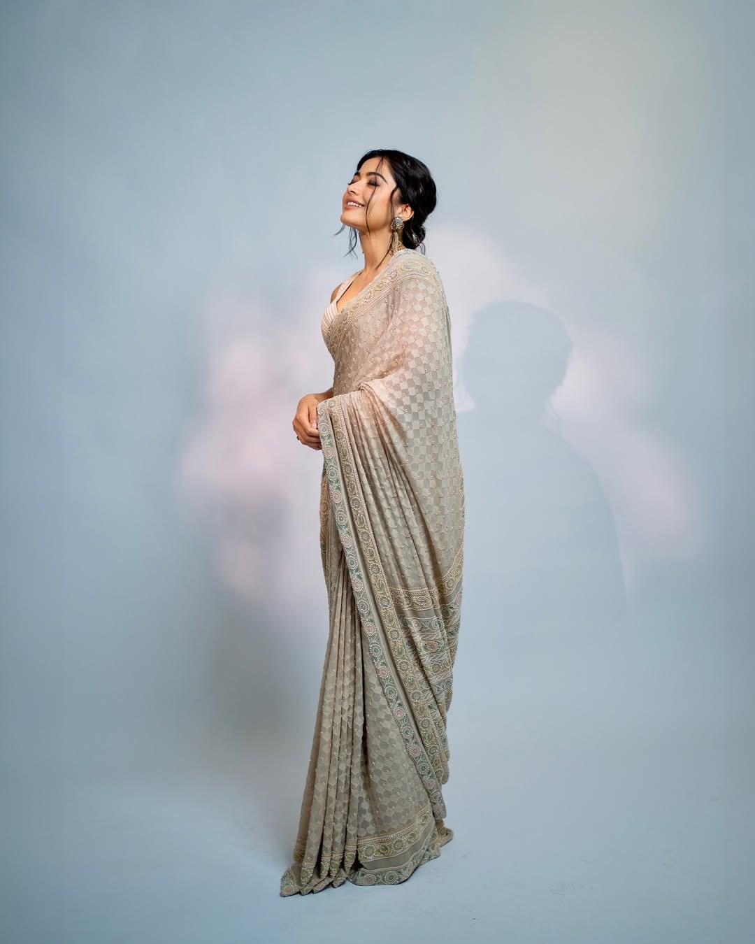 For a truly graceful look, go for an ornately embroidered grey saree like Rashmika here.