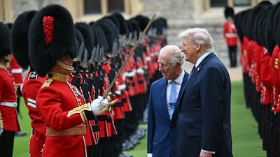 Britain's King Charles III and US President Donald Trump talk with a Coldstream Guardsman as they inspect the guard of honour during a ceremonial welcome in the Quadrangle at Windsor Castle. (AFP photo) 