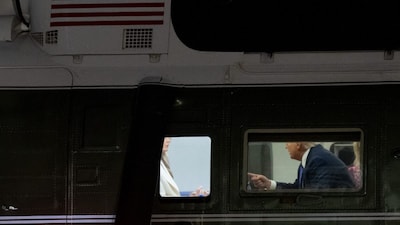 US President Donald Trump speaks with First Lady Melania Trump onboard Marine One. (AFP)