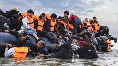 Migrants try to board a smuggler's boat in an attempt to cross the English Channel off the beach of Gravelines, northern France. (IMAGE: AFP)