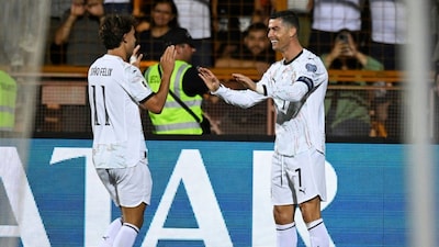 Portugal's Cristiano Ronaldo, right, celebrates with Joao Felix after scoring his side's fourth goal during a World Cup 2026 group F qualifying soccer match between Armenia and Portugal at the Vazgen Sargsyan stadium in Yerevan, Armenia, Saturday, Sept. 6, 2025. (AP Photo/Hakob Berberyan)
