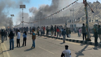 Smoke rises from a police vehicle that was torched by demonstrators near the BJP office in Leh on September 24. (Image: Tsewang RIGZIN/AFP)