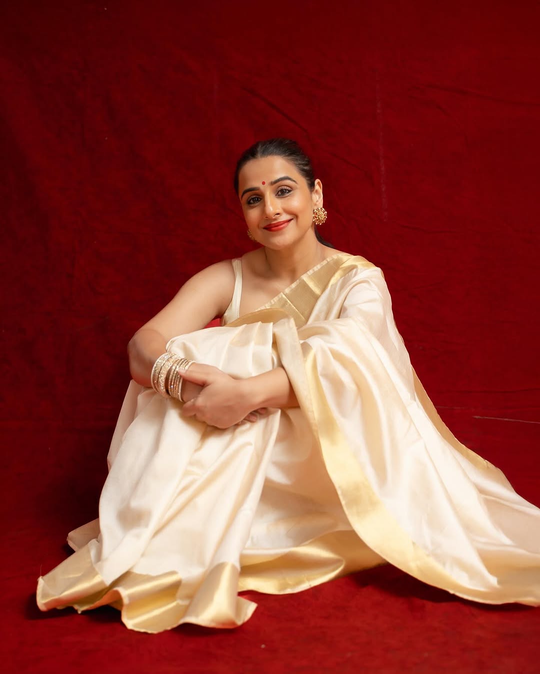 On Navratri Day 1, Vidya Balan chose a bespoke white and golden Kasavu saree. She paired it with a simple sleeveless white blouse. 