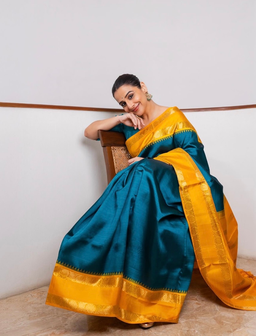 An orange silk saree with a blue border and a sleeveless blouse was Vidya's Navratri Day 7 look. An orange silk saree with a blue border and a sleeveless blouse was Vidya's Navratri Day 7 look.