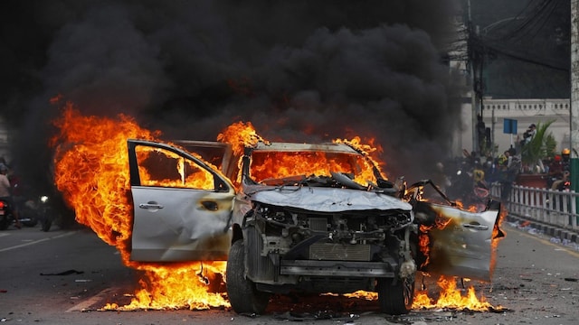 A car burns outside the Singha Durbar, the main administrative building of the Nepal government, in Kathmandu on September 9. (AFP photo)