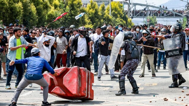 Demonstrators weild stones and sticks as they clash with riot police personnel during a protest outside the Parliament in Kathmandu. (AFP)