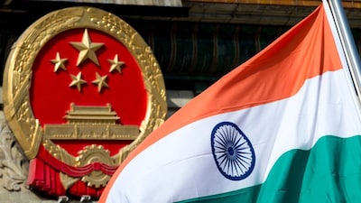 An Indian national flag is flown next to the Chinese national emblem during a ceremony in Beijing. (AP file photo)