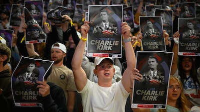 An attendee holds an American flag during a Turning Point USA rally at Utah State University, as a part of the organization's push to memorialize Charlie Kirk. (IMAGE: AP PHOTO)