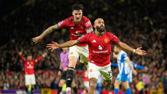 Manchester United's Bryan Mbeumo, front, celebrates with Benjamin Sesko after scoring his side's third goal during the English Premier League soccer match between Manchester United and Brighton & Hove Albion in Manchester, England, Saturday, Oct. 25, 2025. (AP Photo/Dave Thompson)