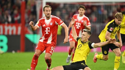 Bayern's Harry Kane, left, and Dortmund's Nico Schlotterbeck, centre, in action during the Bundesliga soccer match between Bayern Munich and Borussia Dortmund in Munich, Germany, Saturday, Oct. 18, 2025. (AP Photo/Lennart Preiss)
