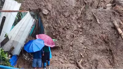Darjeeling: People stand next to a structure buried under debris after landslides due to heavy rainfall (Photo: PTI)