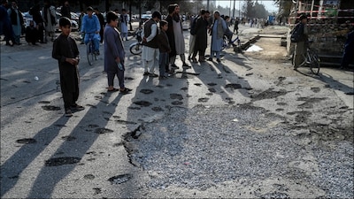 Afghan residents stand next to a damaged road in Kabul after a previous airstrike by Pakistan. (AFP/File)