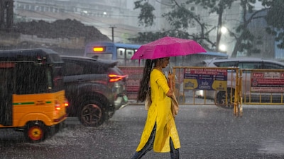 A woman walks with an umbrella on a road during heavy rainfall, in Chennai on Tuesday. (PTI file photo)