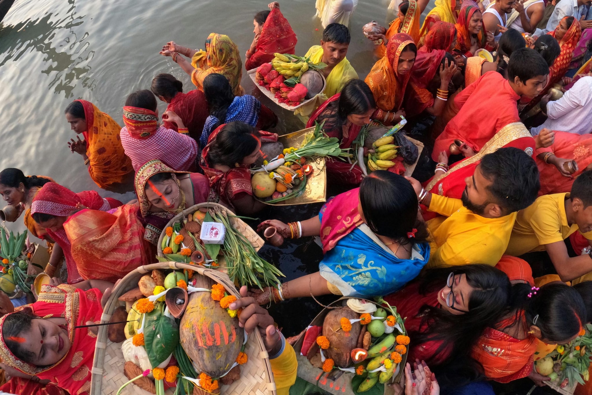 Devotees wade into the water and offer Arghya to the setting sun, praying for the prosperity and well-being of their children and family. Devotees wade into the water and offer Arghya to the setting sun, praying for the prosperity and well-being of their children and family.