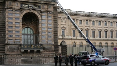 French police officers stand next to a furniture elevator used by robbers to enter the Louvre Museum. (AFP)
