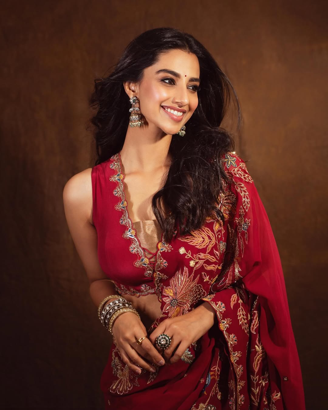 No festive wardrobe is complete without a gorgeous red saree! Wear it with a deep V-neck blouse for added drama. No festive wardrobe is complete without a gorgeous red saree! Wear it with a deep V-neck blouse for added drama.