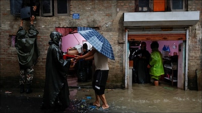 Members of Nepal Army help people retrieve their belongings to a safe area at a flooded street in Nepal. (Reuters)