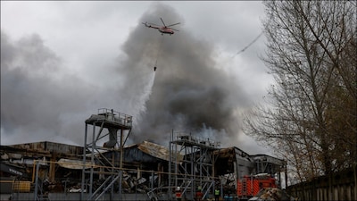 A firefighting helicopter drops water over food warehouses hit by an overnight Russian missile strike, amid Russia’s attack on Ukraine. (Reuters)