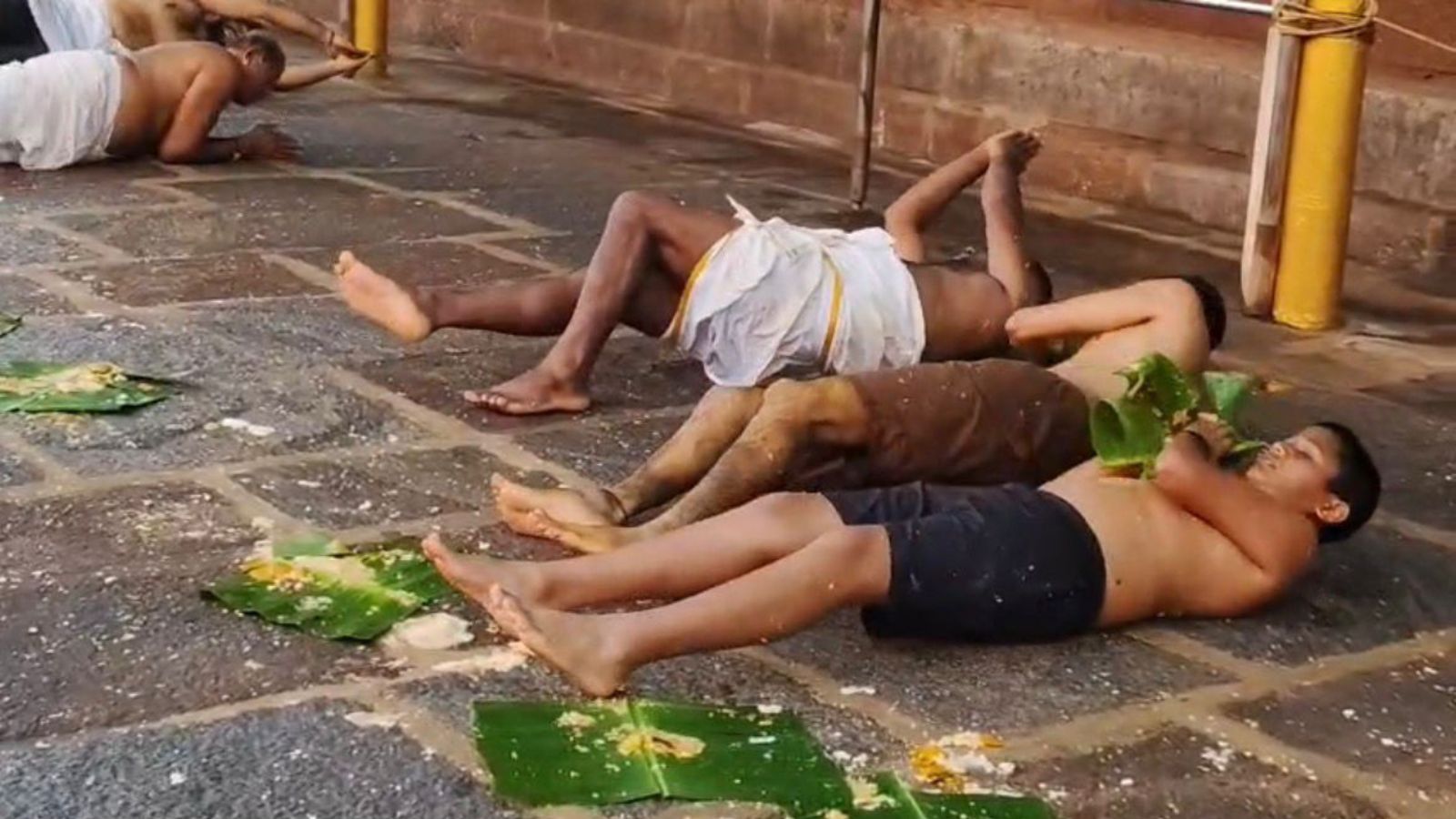 Devotees Performing Edemadesnana ritual during Champa Shashti in temple premises.