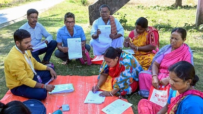 A BLO oversees the filling of enumeration forms by voters for the special intensive revision of electoral rolls, in West Bengal's Malda district. (Image: PTI/File)