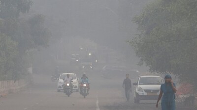 Vehicles move on a road shrouded in smog in New Delhi. (IMAGE: REUTERS) 