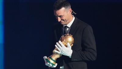 Argentina's coach Lionel Scaloni brings the World Cup trophy on stage during the draw for the 2026 FIFA World Cup. (AP Photo)