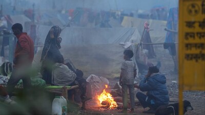 New Delhi: People warm themselves near a makeshift fire on a cold winter morning (Photo: PTI)