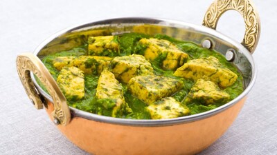 Palak Paneer: Perhaps the most iconic spinach dish in India, palak paneer is a North Indian classic. Fresh spinach leaves are blanched and pureed, then simmered with onions, garlic, ginger, and spices to create a creamy base. Cubes of paneer (Indian cottage cheese) are added, absorbing the flavors beautifully. Served with roti or naan, this dish is a staple winter comfort food. (Image: Canva)