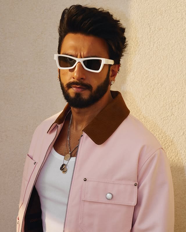 Ranveer a complété son look avec des lunettes de soleil rétro blanches dotées d'une monture épaisse. Ce style était le premier qu'il a fait ses débuts lors du match NBA Abu Dhabi 2022, ce qui en fait son article signature. Son jeu de bijoux était fort, avec des chaînes, des médaillons et des bracelets en argent, reflétant l'essor des accessoires pour hommes dans la haute couture. Les clous en diamant ont ajouté une touche finale d'éclat.