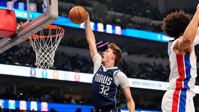 Dallas Mavericks forward Cooper Flagg (32) dunks after getting past Detroit Pistons guard Cade Cunningham, right, in the first half of an NBA basketball game in Dallas, Thursday, Dec. 18, 2025. (AP Photo/Tony Gutierrez)
